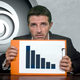 A stock photo of a desperate-looking man holding a downward-trending sales chart. The Ubisoft swirl logo is in the background.